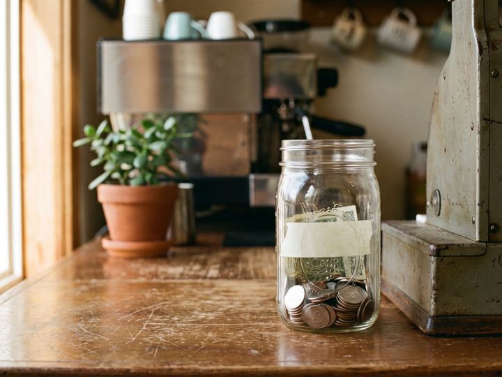 A jar of coins next to a cash register